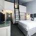 Gravity Haus Steamboat hotel room with loft ladder, king bed and bedside lamps in Steamboat Springs