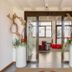 Hotel Borgo Brianteo entrance with glass doors, tall white planters, and red chairs in Ponte San Pietro