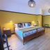 Chateau De Montreuil in Montreuil guest room with king bed, yellow walls, bedside lamps and wood floor
