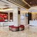 Desheng Hotel Beijing lobby with marble front desk, red seating, and illuminated ceiling accents