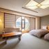 Hotel Kazuno in Kazuno guest room with twin beds, seating area, and large arched window city view