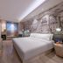 Orange Hotel Beijing Tianning Temple guest room with bed, wall mural, and TV in Beijing.