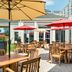 Hilton Garden Inn Dulles North in Ashburn patio with outdoor tables, red umbrellas and seating