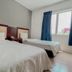 N9 Business Hotel in Kampung Baharu Nilai: twin beds in a simple guest room with window and blue curtains