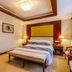 Guoyi Hotel Beijing guest room with king bed, bench, bedside lamps and classic decor