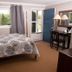 Governor's Rock Motel, Shaftsbury: guest room with bed, window view of trees, and desk by the door