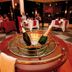 At The Kairaba Beach Hotel in Serrekunda, a champagne bucket sits on a red table in a candlelit dining room.