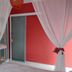 Pousada Mar de Araçatiba room with white canopy bed, sheer curtains, and sliding glass door in Vila do Abraao