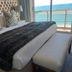 Diaz Hotel & Resort in Mossel Bay room with king bed, bench, and ocean-view balcony