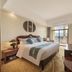 Jingland Exhibition Hotel in Xishuangbanna guest room with balcony view and king bed