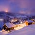 Hotel Lärchenhof in Rennweg am Katschberg with snowy alpine cabins at dusk