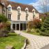 Aux Vieux Remparts in Provins with a cobblestone path, garden landscaping and cream hotel exterior