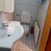 Jaegerstube in Görgeshausen bathroom with sink, toilet, tiled walls and towel radiator