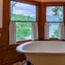 The Lodge on Lake Lure bathroom with soaking tub and lake views through bay windows in Lake Lure
