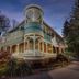 Engadine Inn and Cabins in Candler, Victorian-style inn exterior with wraparound porch at dusk