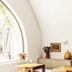 Le Moulin, Lourmarin dining nook with arched window, stone wall, and table setting