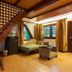 Royal Phawadee Village Patong: loft-style room with wooden stairs, seating area, and garden view