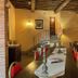 Antica Dimora Leones in Palaia: rustic dining room with brick arches, wood beams and red chairs