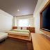 Hotel Mystays Premier Hamamatsucho room in Tokyo with a bed, sofa, desk and wall-mounted TV