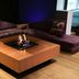 Resort Bad Boekelo lounge with U-shaped sofa and square fire pit on a wood floor in Boekelo