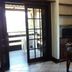 Maratea Mare in Florianopolis: dining table near sliding glass doors and window, with TV corner