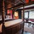 The White Swan Hotel, Stratford-upon-Avon: four-poster bed in a richly decorated guest room with stained-glass window.
