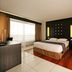 Hotel Tahiti Nui in Papeete guest room with king bed, large window, and wood-accent floor