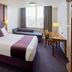 Premier Inn Leicester North West room in Leicester with double bed, desk, sofa and city view