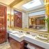 Hakka park International Hotel in Meizhou bathroom with double vanity, wood door, and large mirror