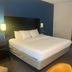 Comfort Inn & Suites Trussville I-59 Exit 141 guest room with king bed, wall mirror and blue accent wall