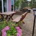 Outdoor patio seating at Zur Fichtenbreite in Klieken with wooden tables, benches and flower planters