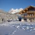 Appartement Sonnengarten in Ramsau am Dachstein, snowy alpine chalet with mountain backdrop