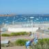 Le Beauséjour in Tregastel overlooking a harbor with boats, terrace seating, and coastal views