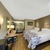 Red Roof Inn Asheville - Biltmore West room with two beds, desk, armchair and bathroom sink