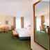 Apart-Hotel Halle in Halle: spacious guest room with bed, sitting area, desk and large mirror