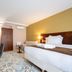 Hôtel Le Yachtman, The Originals Collection in La Rochelle: bright hotel room with bed, seating area and wardrobe