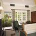 Marygreen Manor Hotel, Brentwood guest room with open patio door, armchair, desk, and bed