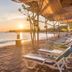 Sunset beach loungers at Amertha Bali Villas in Gerokgak beside calm ocean water