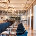 Kurhotel Skodsborg in Copenhagen dining room with long blue banquette seating and chandelier lighting