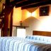 Pouso Sambaquis in Ilhabela room with wooden staircase, double bed and wall lamp