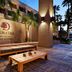 DoubleTree by Hilton Golf Resort Palm Springs courtyard with palm trees, benches and lit walls in Cathedral City