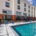 Hampton Inn & Suites by Hilton Tomball Houston NW outdoor pool with lounge chairs and hotel exterior