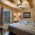 Paradise Hills, Winery Resort & Spa in Blairsville bedroom with wood-paneled walls and ceiling fan