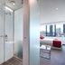 City Tempo Melbourne room with glass shower, bathroom sink, and city-view bedroom window