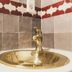 El Riad Andaluz in Málaga: brass bathroom sink and faucet with patterned tiled wall