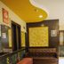 Hotel Park Plaza in Chandigarh lobby with brown leather sofa, patterned bench, and yellow decorative wall art.