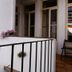 Balcony at Alvares Cabral Guest House in Porto with potted plants and folding chair
