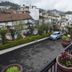 Hotel Apple Valley in Kodaikanal with balcony view of hillside buildings, parked cars and potted flowers