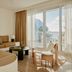 Palm Heights North Side suite with balcony, ocean view, sectional sofa and glass coffee table