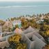 Diamonds Malindi in Malindi with palm trees, ocean view, and thatched-roof resort buildings